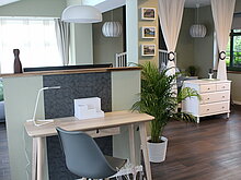 kleiner Schreibtisch und Stuhl mit Blick auf Doppelbett