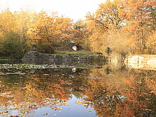 Blick über Steinbruchsee zum Torbogen im Herbst