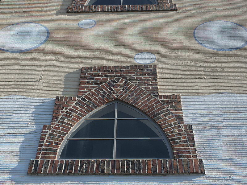 Fenster des Wasserturms. An der Fassade sind aufgezeichnete Wasserblasen zu sehen.