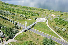 Luftaufnahme der Gremminer Brücke mit Stadtbalkon. Eine kleine Serpentine führt zum Gremminer See.