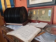 Alte Schallplatten und Notenblätter auf einem Sekretär