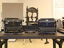 Auf diesem Bild sieht man zwei Schreibmaschinen auf einem Tisch platziert, diese befinden sich in unserem Buchdruckmuseum in Gräfenhainichen. 