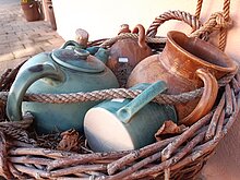 Korb mit Keramikbehältnissen wie Kannen und Töpfe drin